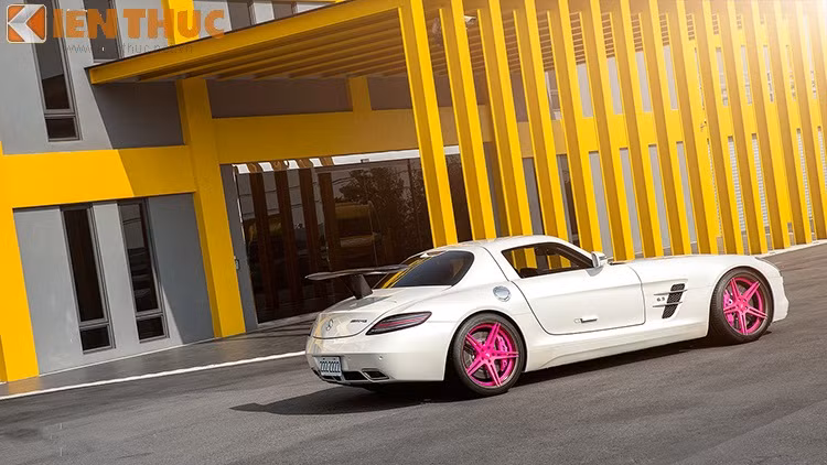 Trong bản độ mới, Mercedes SLS AMG có bộ la - zăng ấn tượng với màu hồng cá tính, nổi bật hoàn toàn trên nền trắng ngọc trai.