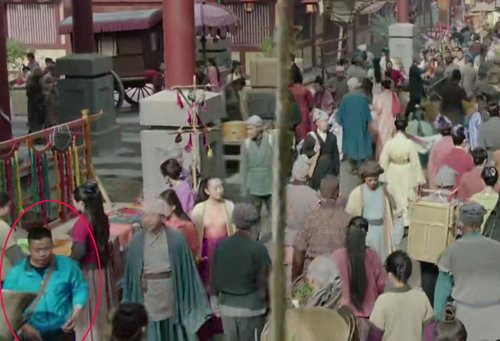 Một nhân viên lấp ló ở góc khung hình.