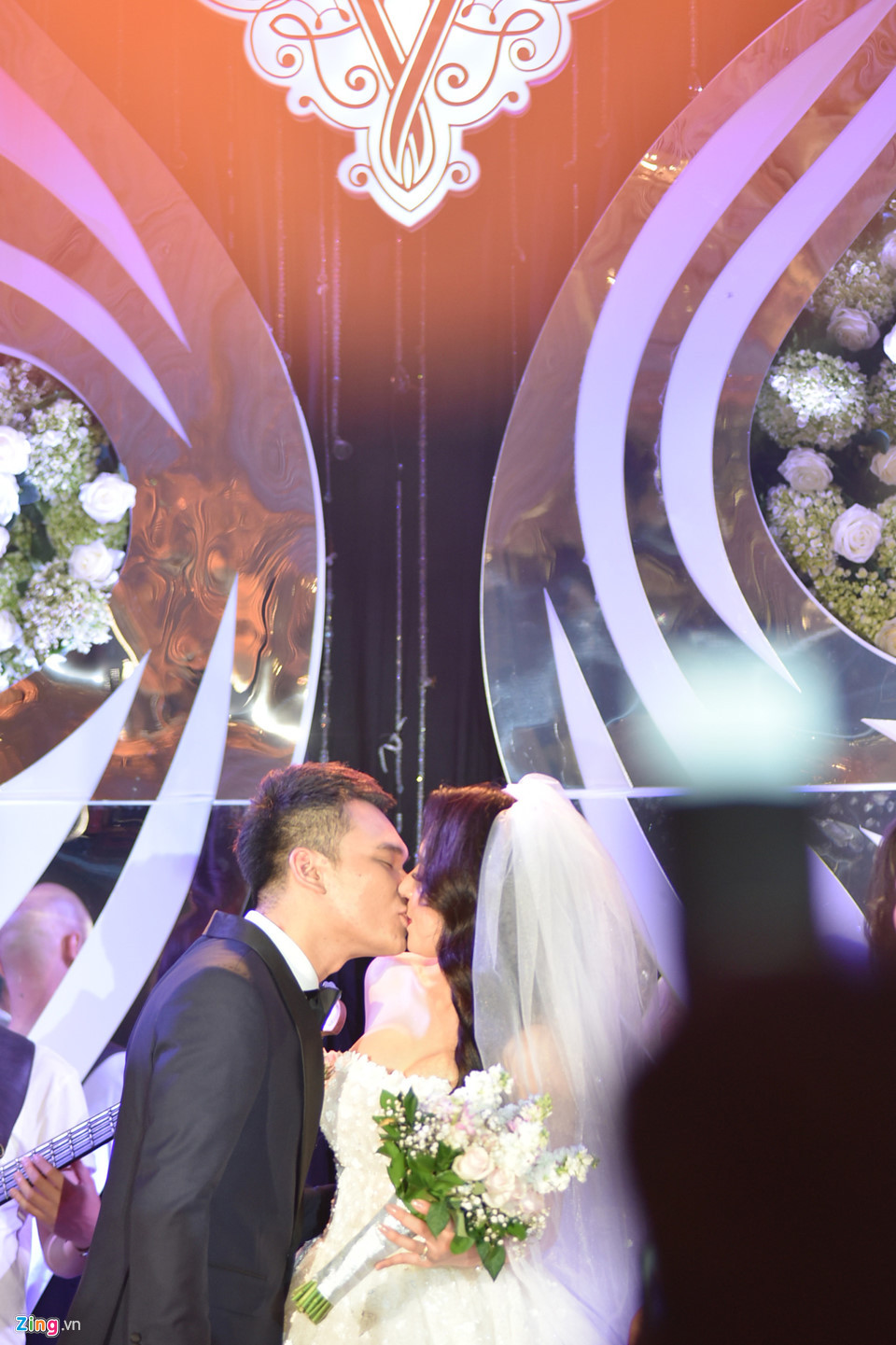 Cả hai trao nhau nụ hôn ngọt ngào trong tiếng reo hò, vỗ tay chúc mừng của người thân, bạn bè.