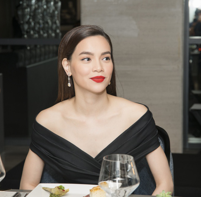 Hồ Ngọc Hà mặc bộ đầm đen trễ vai và tô son rực rỡ, trông vừa quyến rũ, vừa kiêu sa. Gần đây cô lấn sân kinh doanh son môi và đạt được thành công bước đầu.