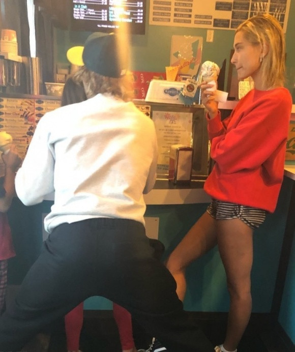 Theo quan sát, Justin Bieber mặc áo trắng, quần đen, đội mũ còn vị hôn thê của anh diện áo đỏ, quần short kẻ. Hai ngôi sao cùng các em dừng chân ở một tiệm bán kem.