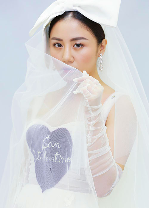 Nữ ca sĩ tạo dáng e ấp trong bộ đầm trắng.