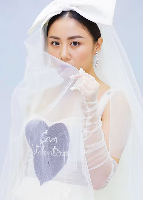 Nữ ca sĩ tạo dáng e ấp trong bộ đầm trắng.