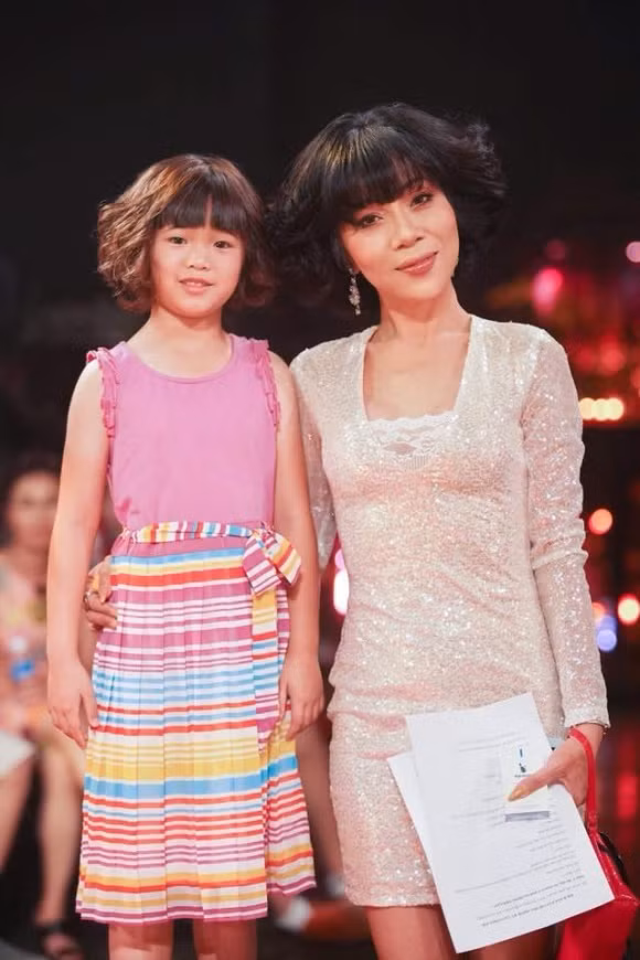 Bé Nguyệt Cát diện váy màu hồng, phần chân bảy sắc cầu vồng vô cùng nổi bật.