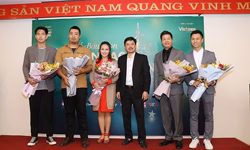 Nhà báo Lê Xuân Thành đại diện tặng hoa cho các nghệ sĩ có tên trong danh sách đề cử. Ảnh: BTC