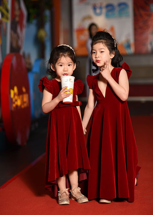 Hai nhóc tì ăn mặc ton-sur-ton với mẹ và tạo dáng đáng yêu trên thảm đỏ.