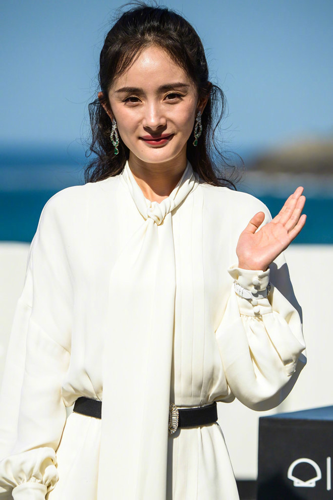 Trong ảnh, Dương Mịch đứng bên bờ biển để tạo dáng cùng các nghệ sĩ khác. Cô mặc một bộ váy dài màu trắng nhẹ nhàng bay bổng, mái tóc đen xoăn nhẹ thả bồng bềnh. Tuy nhiên, hình ảnh mang lại không hoàn hảo như Dương Mịch mong muốn.