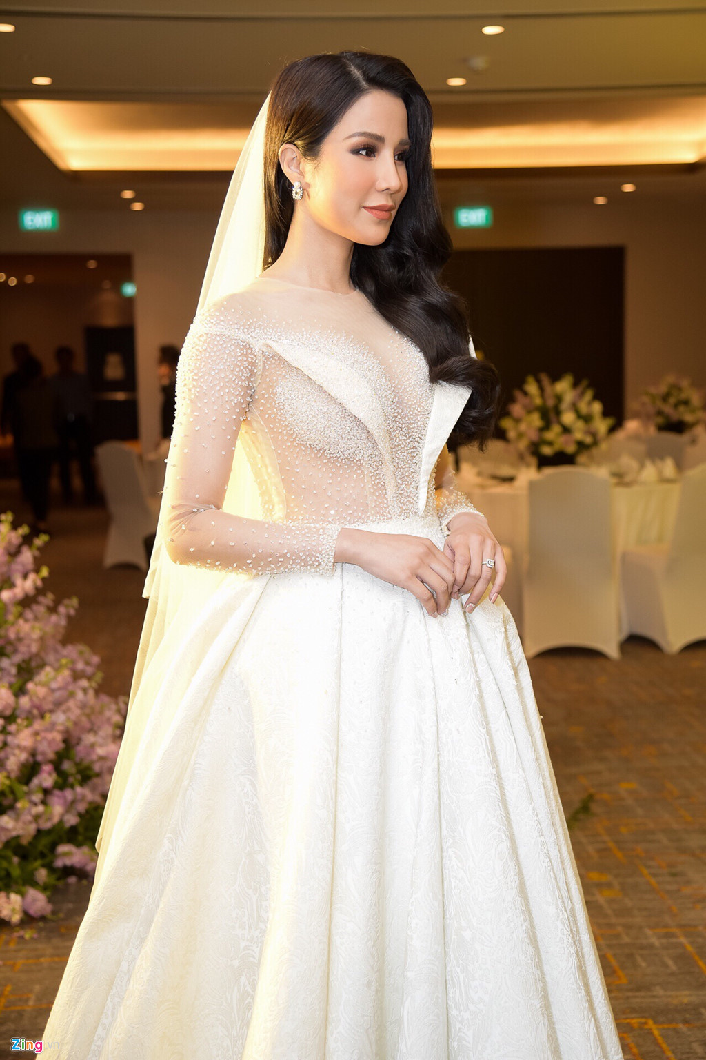 Diệp Lâm Anh thay một chiếc đầm trắng cầu kỳ khác sau khi đón khách. Thiết kế của Lê Thanh Hòa giúp cô dâu khoe vòng một gợi cảm và giấu bụng "lùm lùm".