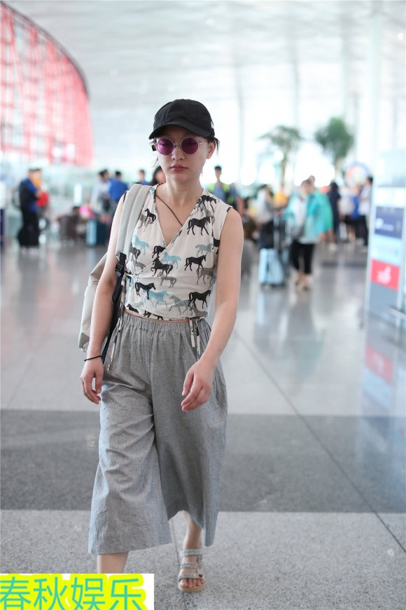 Cô đội mũ, đeo kính tròn sành điệu và mang theo túi xách đồng điệu với trang phục.