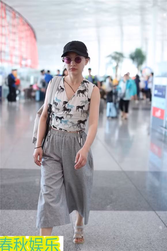 Cô đội mũ, đeo kính tròn sành điệu và mang theo túi xách đồng điệu với trang phục.