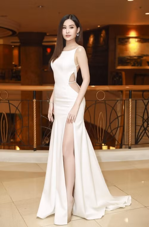 Tại hầu hết các sự kiện, người đẹp đều trung thành với phong cách gợi cảm. Chiếc váy với tông trắng, nền vải bóng, thân váy cắt xẻ phần tà, mang đến người đẹp sinh năm 1995 vẻ ngoài nổi bật, hút ánh nhìn.