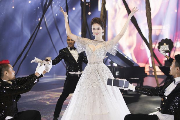 Ngọc Trinh mở màn xinh đẹp như 1 nàng công chúa. Thiết kế này gây chú ý với đường khoét sâu táo bạo hình trái tim khoe vòng 1 căng tràn của người mặc.