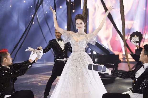 Ngọc Trinh mở màn xinh đẹp như 1 nàng công chúa. Thiết kế này gây chú ý với đường khoét sâu táo bạo hình trái tim khoe vòng 1 căng tràn của người mặc.