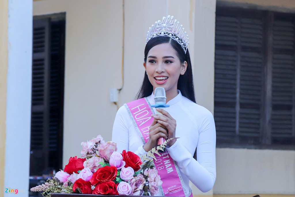 Tiểu Vy diện áo dài trắng, có mặt lúc 7h sáng để tham dự lễ chào cờ đầu tuần. Cô trao học bổng cho 20 học sinh xuất sắc của trường cũ. Cô rất xúc động khi phát biểu trước toàn trường và đã khóc.