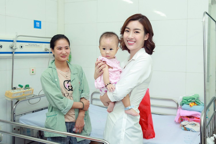 Hoa hậu Đỗ Mỹ Linh bế một em nhỏ trong bệnh viện.