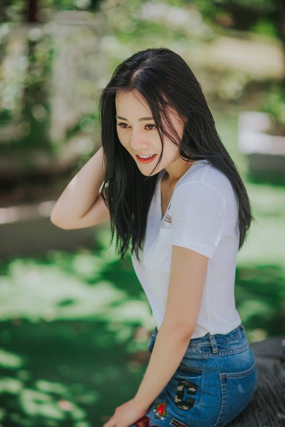 Nữ diễn viên giản dị với quần jeans xanh và áo phông trắng.