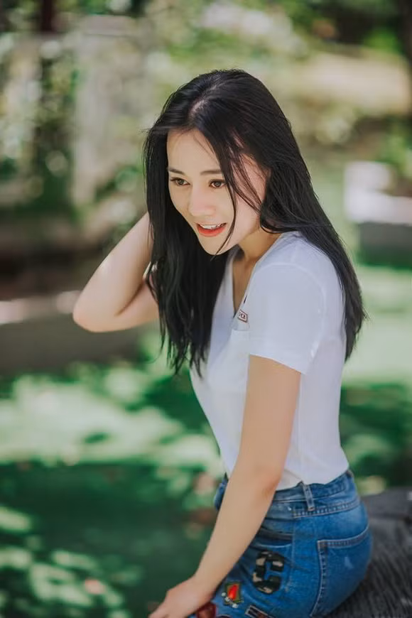 Nữ diễn viên giản dị với quần jeans xanh và áo phông trắng.