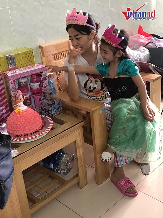 Bé Lavie ngồi chơi trong lòng mẹ ngoan ngoãn.