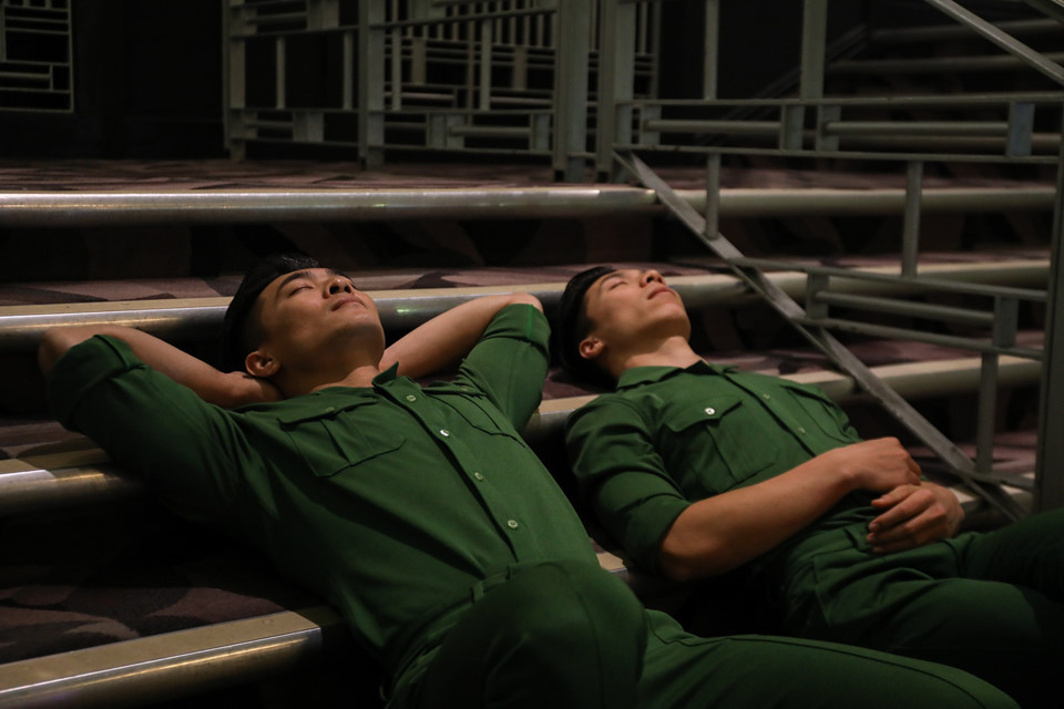 Ngay gần giờ diễn, Quốc Cơ - Quốc Nghiệp có những phút thư giãn hiếm hoi. Cả hai nằm nghỉ ngay trên bậc cầu thang ở hậu trường, chuẩn bị sức khỏe và tâm lý cho tiết mục đòi hỏi nhiều nỗ lực.