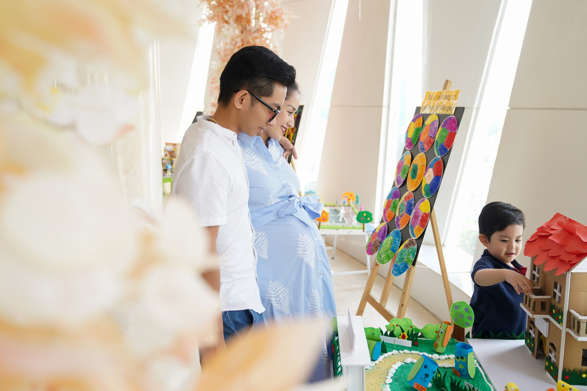 Cặp đôi hạnh phúc ngắm nhìn con trai chơi đùa.