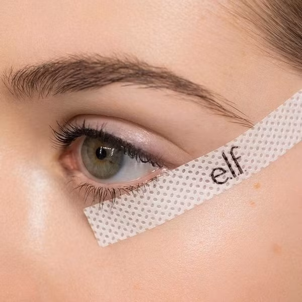 Hãy dán miếng dán kẻ mắt theo đường viền mi mắt, rồi dùng bút tô theo đường viền khung có sẵn.