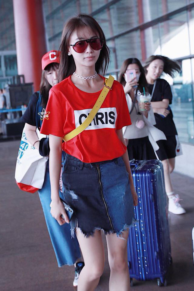 Style sân bay trẻ trung, năng động cùng áo phông và chân váy jeans lại khiến cô lộ rõ đôi chân khẳng khiu, đầu gối củ lạc.