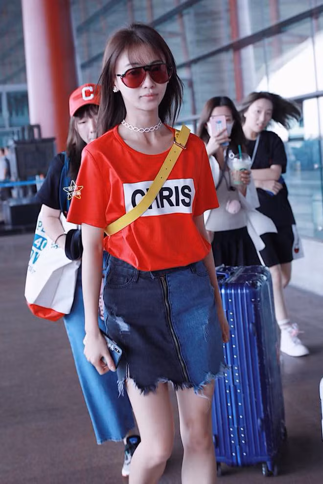 Style sân bay trẻ trung, năng động cùng áo phông và chân váy jeans lại khiến cô lộ rõ đôi chân khẳng khiu, đầu gối củ lạc.