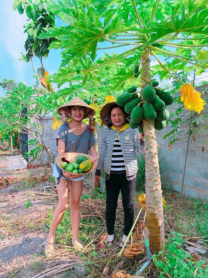 Minh Hà khoe một nón đựng đầy đu đủ xanh và chín.