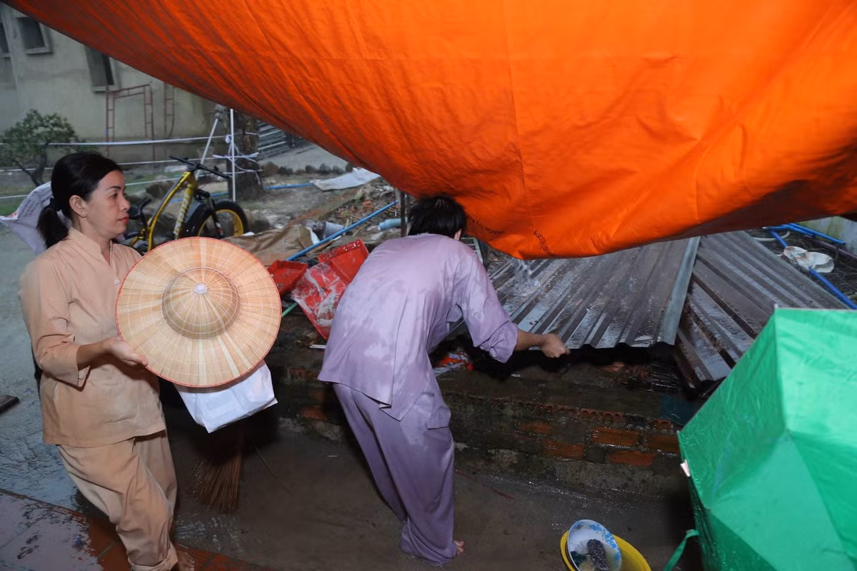 Mưa to và giông lớn kéo đến dữ dội khiến rạp che bên cạnh đền thờ bị tốc phần mái, nước mưa chảy tràn vào bên trong nơi nghỉ chân của quan khách.