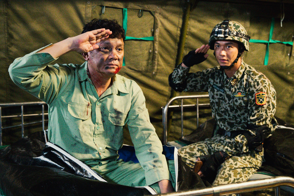 Là nghệ sĩ đàn anh, đàn chú với bề dày kinh nghiệm, Hữu Châu thường xuyên có những góp ý, chỉ dẫn cho các diễn viên trẻ như Song Luân, Khả Ngân, Cao Thái Hà, Hữu Vi. Trong ảnh, nghệ sĩ Hữu Châu đang hướng dẫn Song Luân cách giơ tay chào tiễn biệt theo quy tắc quân đội.