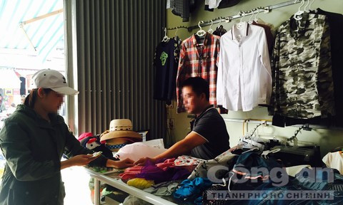 Anh Minh đang bán thanh lý số quần áo ở cửa hàng để lấy tiền trả nợ.