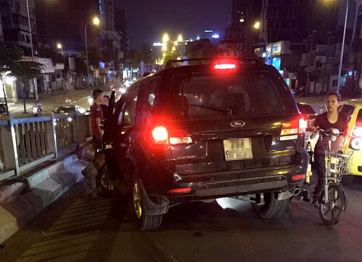 Khoảng 21h40 ngày 21/5, ôtô 7 chỗ Ford Escape mang biển số Hà Nội lưu thông trên đường Láng Hạ (quận Đống Đa). Đến giữa cầu vượt Láng Hạ, xe đâm mạnh vào chiếc Toyota Fortuner màu trắng. Ảnh: Trường Hiếu.