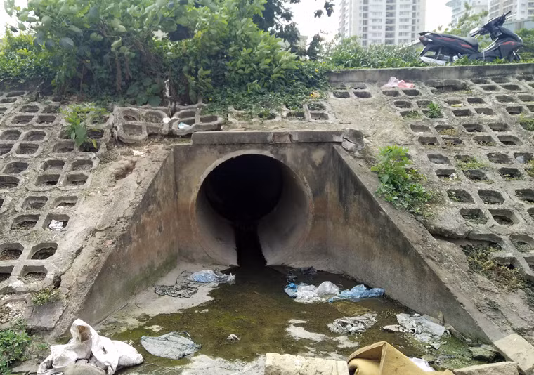 Một cửa cống xả nước thải sinh hoạt của người dân vào hồ Đền Lừ đầy túi nilon.