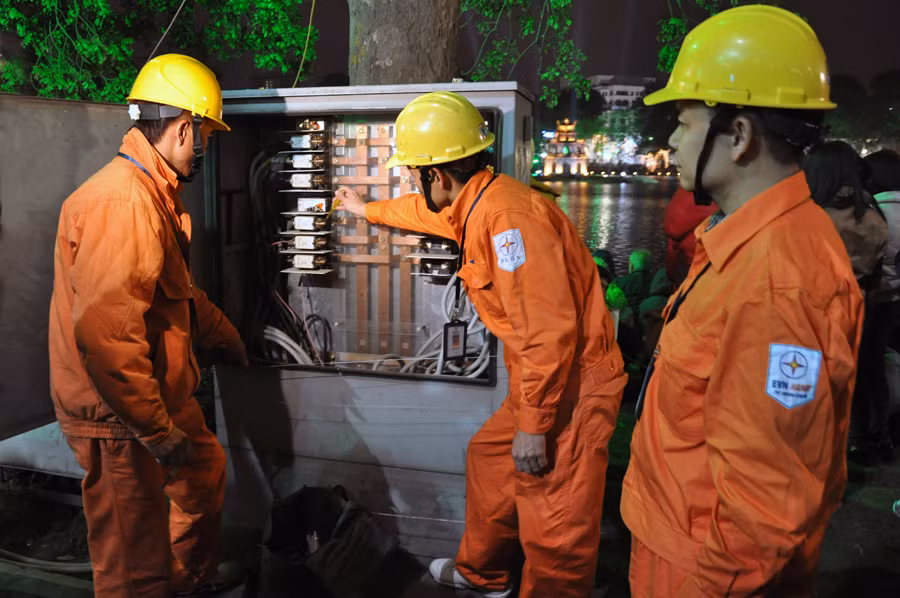 Công nhân Công ty Điện lực Hoàn Kiếm kiểm tra tủ điện khu vực Hồ Hoàn Kiếm - Ảnh: Hoa Việt Cường