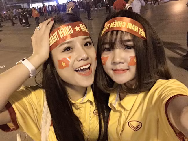 Rất nhanh chóng, danh tính, tên tuổi của 2 nữ cổ động viên đã được dân mạng Việt phát hiện. Người đứng bên trái là Thương Võ, đi cùng với cô bạn Tân Xuân đến sân VĐV Mỹ Đình để theo dõi trực tiếp trận đấu bán kết lượt về AFF Cup 2016 và cổ vũ cho ĐT Việt Nam. Giống như nhiều khán giả, CĐV đến sân khác, hai cô bạn cũng có cách ăn mặc, hóa trang mang đậm màu cờ sắc áo của tuyển Việt Nam và có những khoảnh khắc vui vẻ trước và trong khi trận đấu diễn ra.