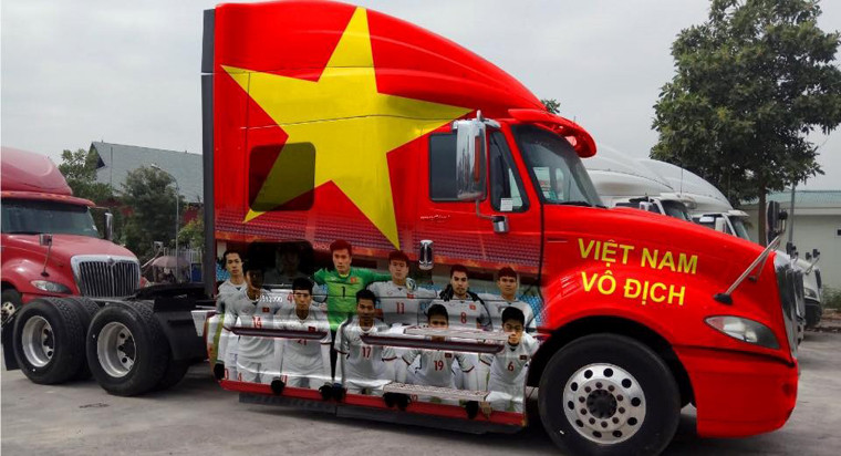 Một chủ phương tiện xe đầu kéo container đã bày tỏ tình yêu bóng đá nước nhà bằng cách bỏ ra hàng chục triệu đồng để sơn lá cờ đỏ sao vàng cực lớn và dán hình các cầu thủ U23 Việt Nam.