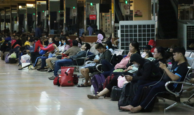 Hành khách nằm ngồi la liệt ở nhà ga để chờ dứt mưa tìm đường trở về nhà cho kịp ngày làm việc sáng nay.