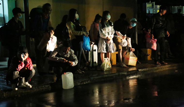 Trông ngóng người thân đến rước hoặc những chuyến xe buýt đến để trở về nhà của hành khách dưới cơn mưa.