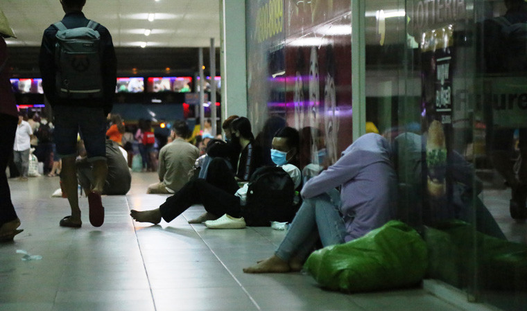 Những hàng ghế ngồi trong khu nhà chờ bến xe miền Đông không còn chỗ trống khiến hành khách phải vật vả dưới nền.