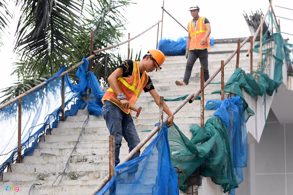 Cầu thang bộ từ vỉa hè lên xuống nhà ga nhếch nhác, chằng chắn lan can bằng các ống sắt tạm bợ cùng các tấm lưới bạt rách rưới.