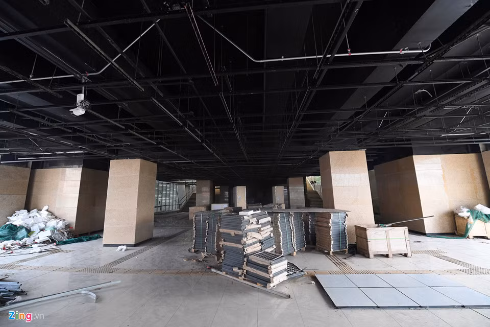 Bên trong sảnh chờ tầng 2, nhiều kiện thiết bị xếp chồng chất, hạ tầng điện, điều hòa, camera giám sát... đang thi công dang dở.