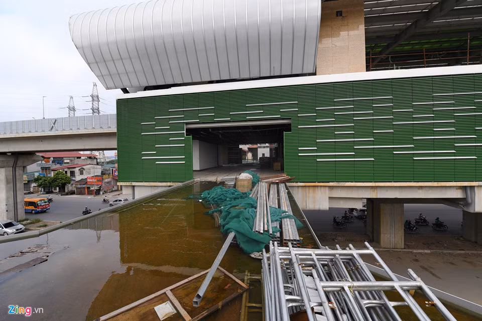 Cầu thang bộ dẫn vào nhà ga ngổn ngang giàn giáo, ngập trong nước mưa như ao tù tụ đọng lâu ngày.