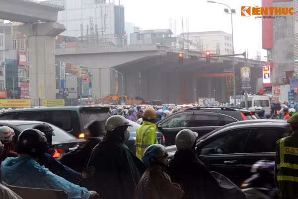 8h sáng, mật độ giao thông trở nên đông đúc hơn cộng thêm lượng mưa lớn càng khiến giao thông ở ngã tư Nguyễn Trãi - Khuất Duy Tiến hỗn loạn, lực lượng CSGT gần như bị các phương tiện "bao vây".