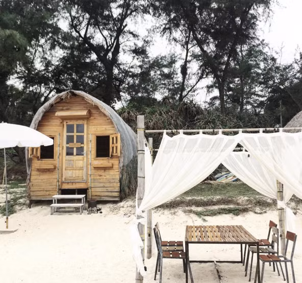 Trên bãi cát là những căn nhà gỗ được thiết kế sáng tạo, gần gũi với thiên nhiên, nơi bạn chỉ cần mở cửa phòng là đã có thể hòa mình vào làn nước biển trong xanh, mát lạnh.
