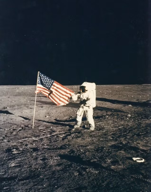 Phi hành gia Pete Conrad chụp ảnh bên lá cờ Mỹ.