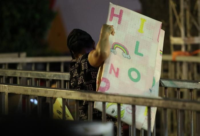 Người dân vận chuyển chiếu, gối, đồ ăn nước uống,... vào bên trong hàng rào phân cách để nằm chờ (Ảnh: Anh Thư)