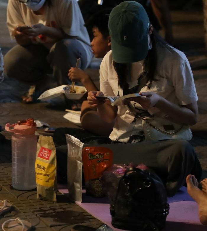 Một CĐV nữ mang theo nhiều đồ ăn vặt, nước,... và tranh thủ đọc truyện tranh (Ảnh: Anh Thư)