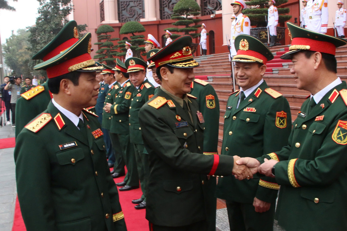 Đại tướng Nguyễn Tân Cương giới thiệu các thành viên Đoàn đại biểu quân sự cấp cao QĐND Việt Nam tại lễ đón.