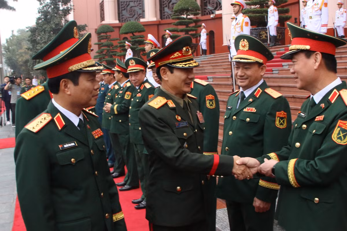 Đại tướng Nguyễn Tân Cương giới thiệu các thành viên Đoàn đại biểu quân sự cấp cao QĐND Việt Nam tại lễ đón.