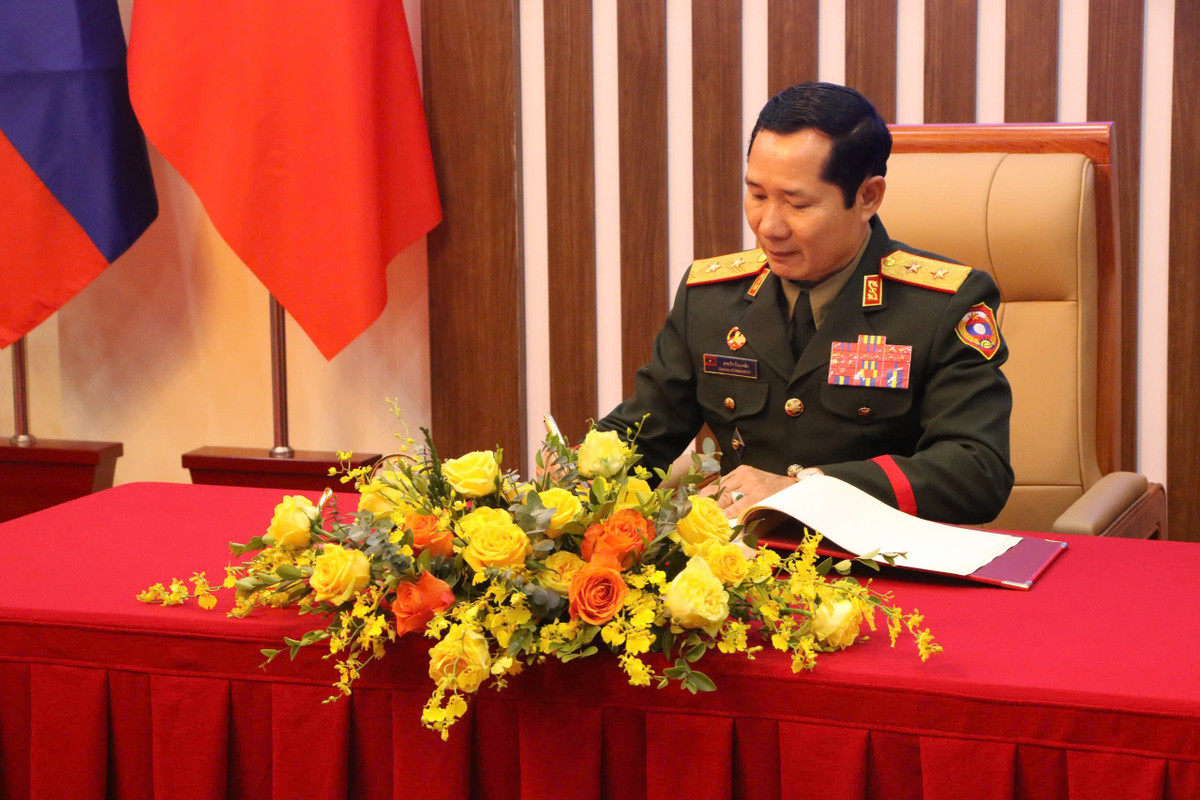 Trung tướng Saichay Kommasith ghi sổ vàng lưu niệm.